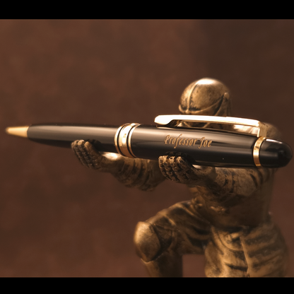 A black and gold pen with 'Professor Ink' engraved on the clip, held horizontally by a bronze-colored statue of a soldier aiming a rifle, against a dark brown background.