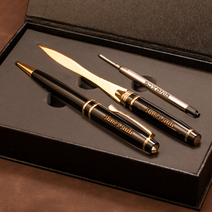A luxury stationery gift set inside a black presentation box, featuring a black and gold ballpoint pen, a matching gold and black letter opener, and a silver and black precision pen repair tool. The pen and letter opener are engraved with 'Mieru Studio'.