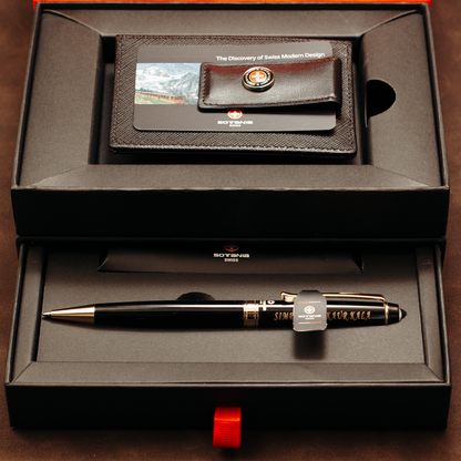 A Swiss Made pen gift set displayed in an open black presentation box. The set includes a black pen with gold trim, a black leather wallet/card holder with a mountain photo and Swiss Made logo, and a black pen sleeve.