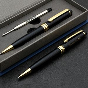 A luxury black ballpoint pen and matching mechanical pencil set with gold accents, presented inside a dark gray gift box on a dark textured surface.