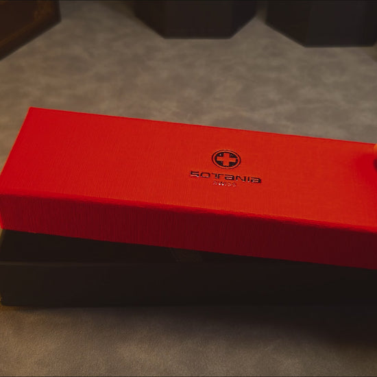 A gift box opening to reveal a custom engraved brass ballpoint pen